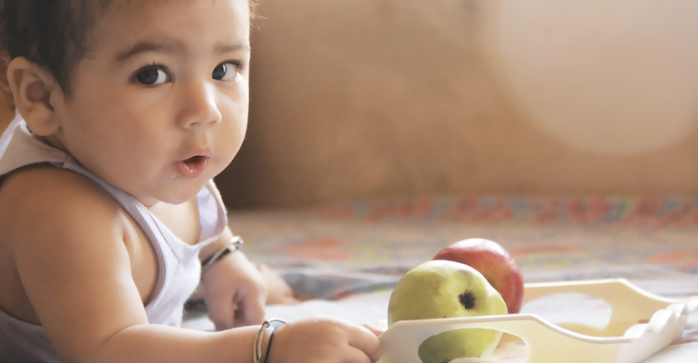 Baby with apples, symbolizing adoptive nutrition